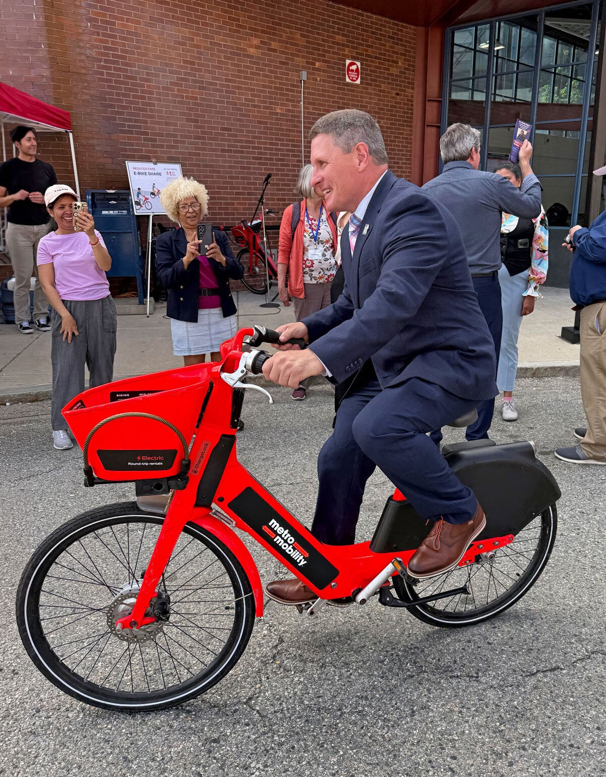 Lowell Mayor Erik Gitschier rides one of the new Metro Mobility e-bikes